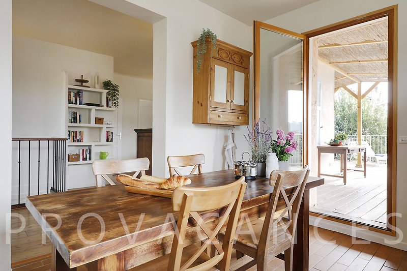 Wohnzimmer mit Holzmöbeln, Tisch, Pflanze und gemütlichem Sofa.
