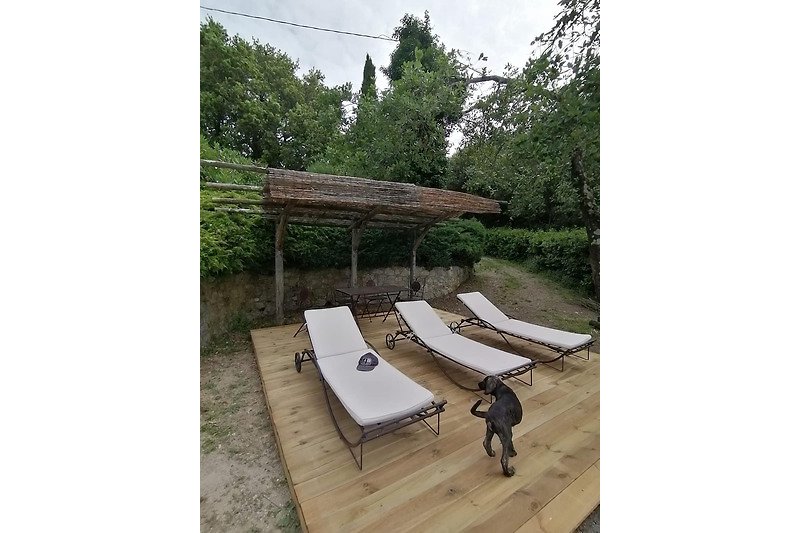 Holzterrasse mit Outdoor-Möbeln und Schatten.