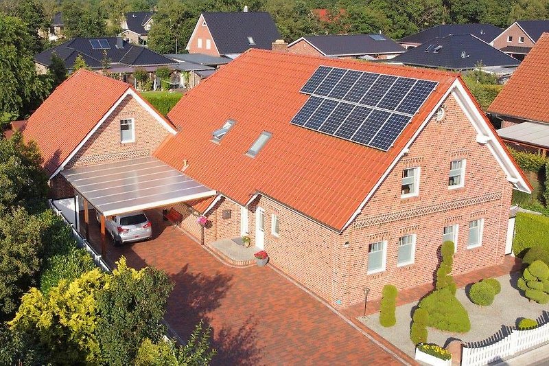Ländliches Haus mit Solarpanelen und Garten.