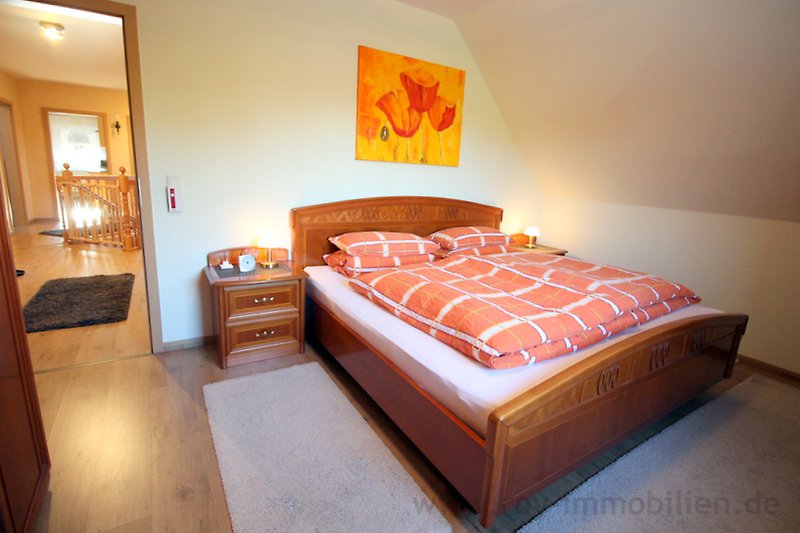 Stilvolles Schlafzimmer mit Holzmöbeln, Bett und Lampen.