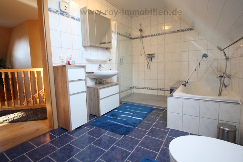 Modernes Badezimmer mit lila Akzenten, Dusche, Spiegel und Waschbecken.