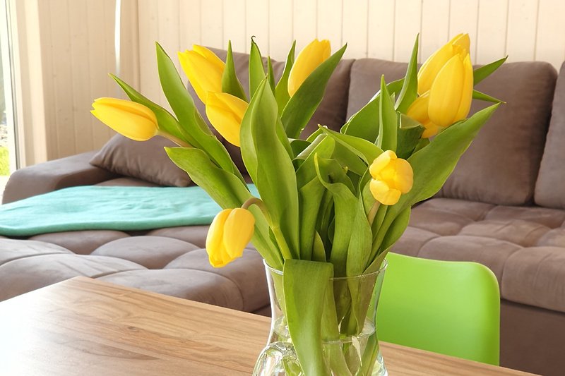 Blumenarrangement auf Tisch mit Vasen.