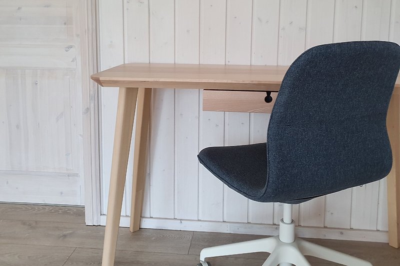 Holztisch, Stuhl, Regal - natürliche Materialien in modernem Raum.