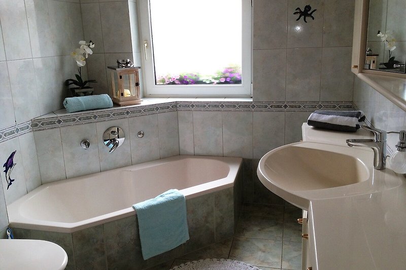 Modernes Badezimmer mit Wanne und WC.