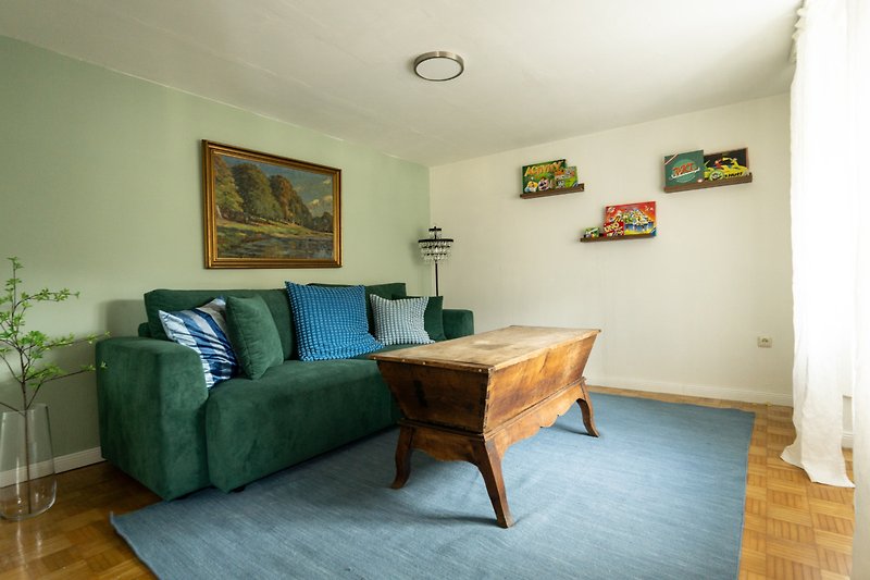 Wohnzimmer mit bequemer Couch, Pflanze und Lampen.