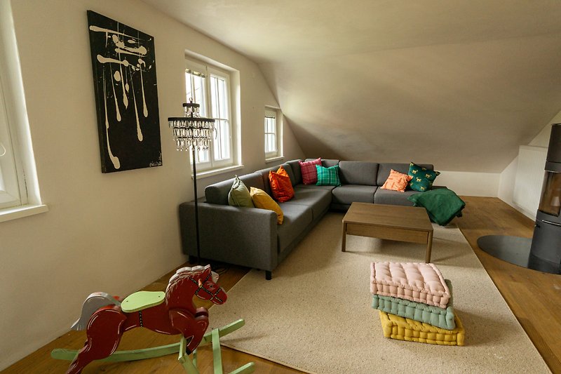 Wohnzimmer mit bequemer Couch, Tisch und Hund.