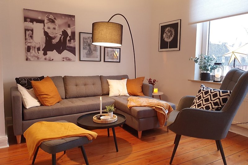 Modernes Wohnzimmer mit Holzdielen, gemütlicher Couch und stilvoller Beleuchtung.