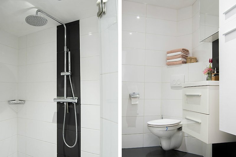 Modernes Badezimmer mit Toilette, Regen Dusche und Fliesen.