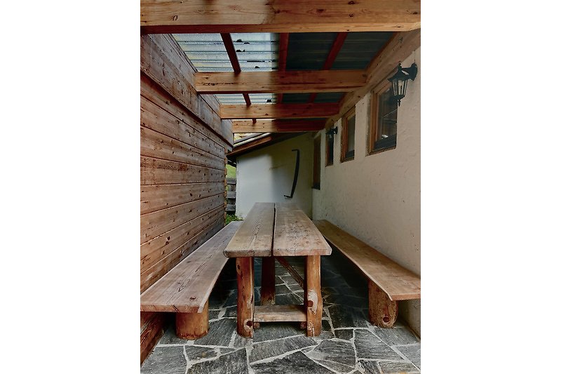 Rustikaler Raum mit Holzdecke, Fenster und Tisch. Gemütliche Atmosphäre.