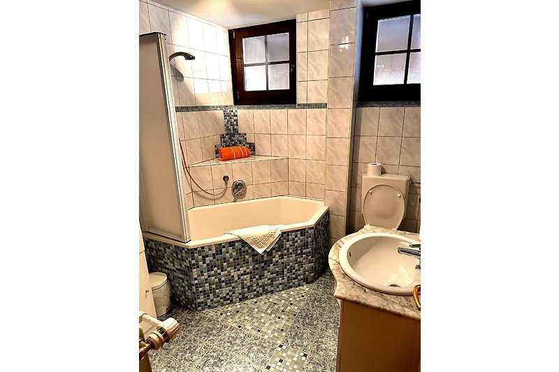 Badezimmer mit braunem Waschbecken, Fenster und Spiegel.