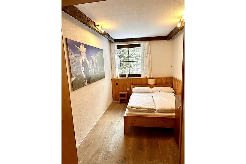 Schlafzimmer mit bequemem Bett, Kissen und Lampe. Gemütliche Atmosphäre.