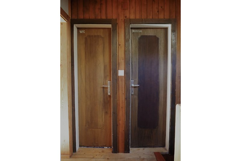 Elegante Holztür mit Metallgriff und Glasfenster.