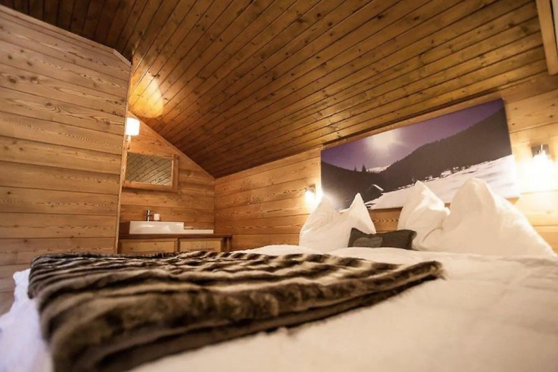 Gemütliches Schlafzimmer mit Holzbalken und Bett.