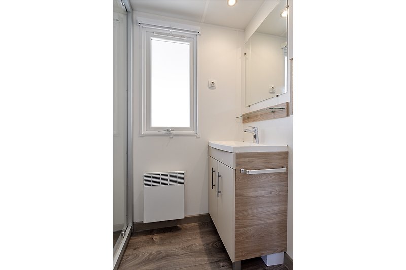 Elegantes Badezimmer mit Spiegel, Waschbecken und Holzakzenten.