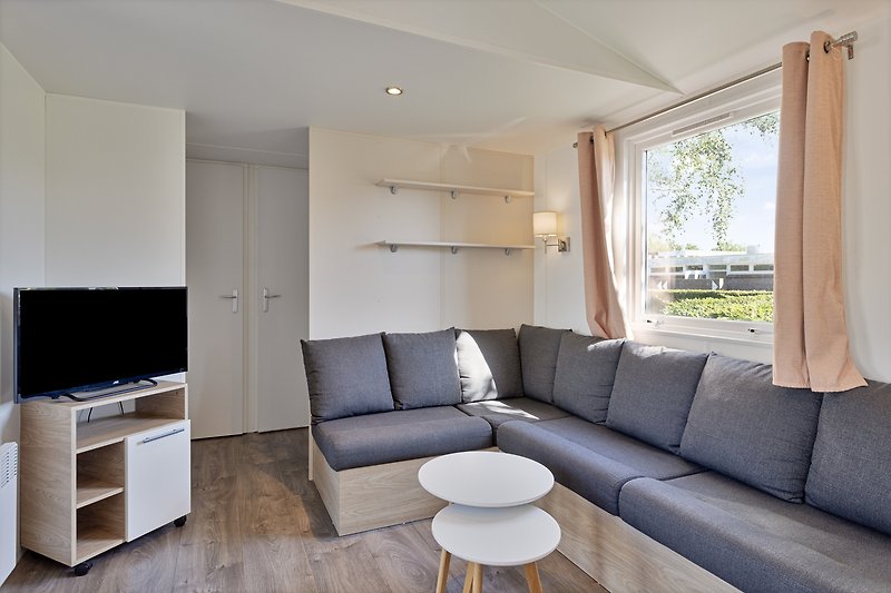 Modernes Wohnzimmer mit Holzmöbeln, gemütlicher Couch und stilvoller Beleuchtung.