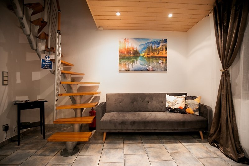 Wohnzimmer mit bequemer Couch, Regal und Pflanze.
