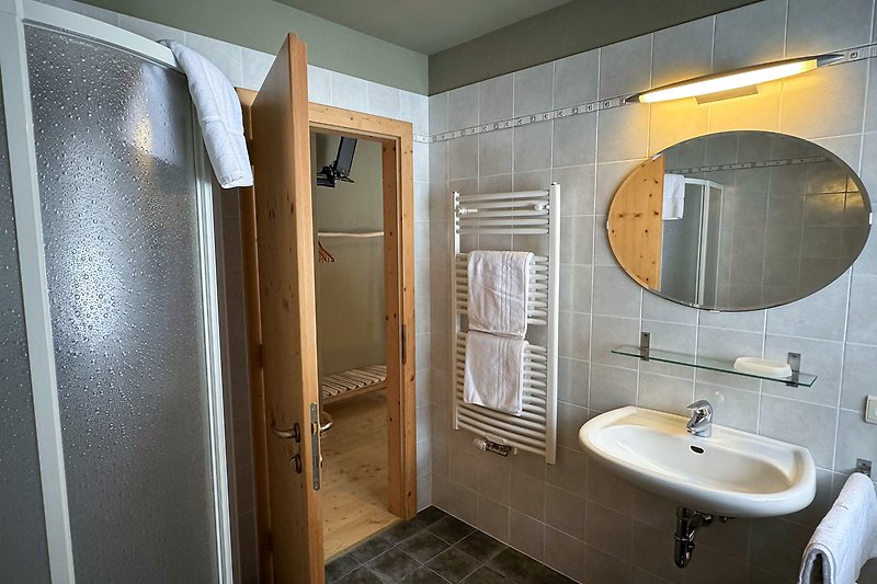 Badezimmer mit Spiegel, Waschbecken und Armaturen.