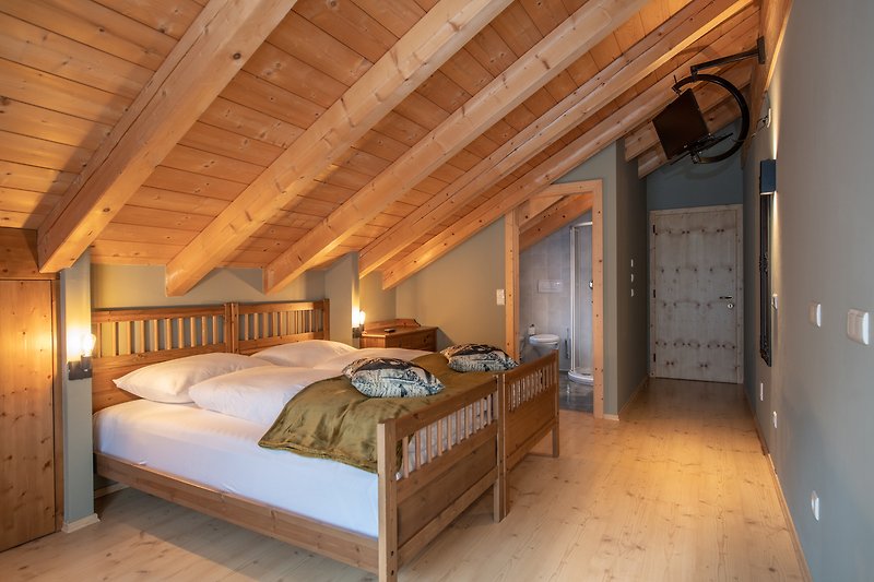 Schlafzimmer mit Holzmöbeln, Bett und Lampe.