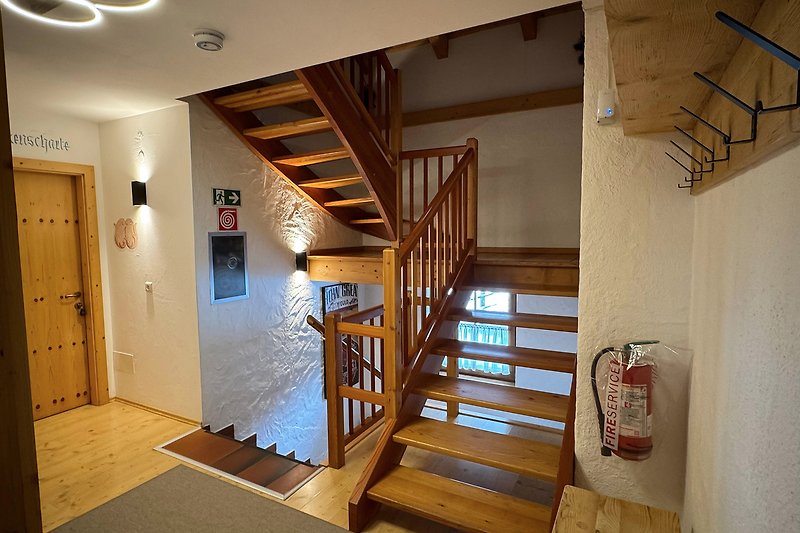 Holzinterieur mit Treppe, Balken und Tür.