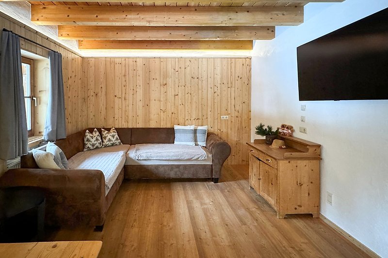 Wohnzimmer mit gemütlicher Einrichtung und Holzmöbeln.