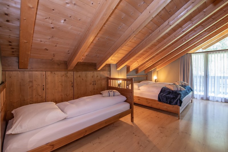 Schlafzimmer mit Holzmöbeln, Bett und Kissen.