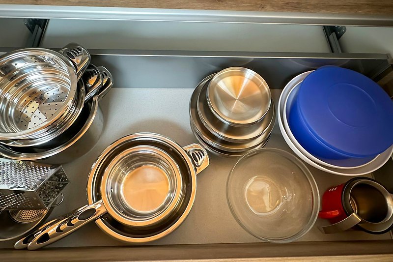 Moderne Küche mit Gasherd, Geschirr und Gläsern.