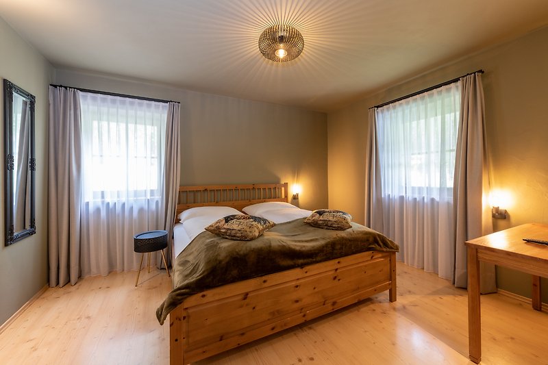 Schlafzimmer mit Holzmöbeln, Bett und Fensterblick.