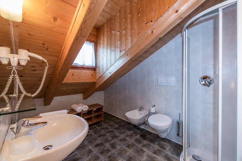 Badezimmer mit Waschbecken, Toilette und Fensterblick.