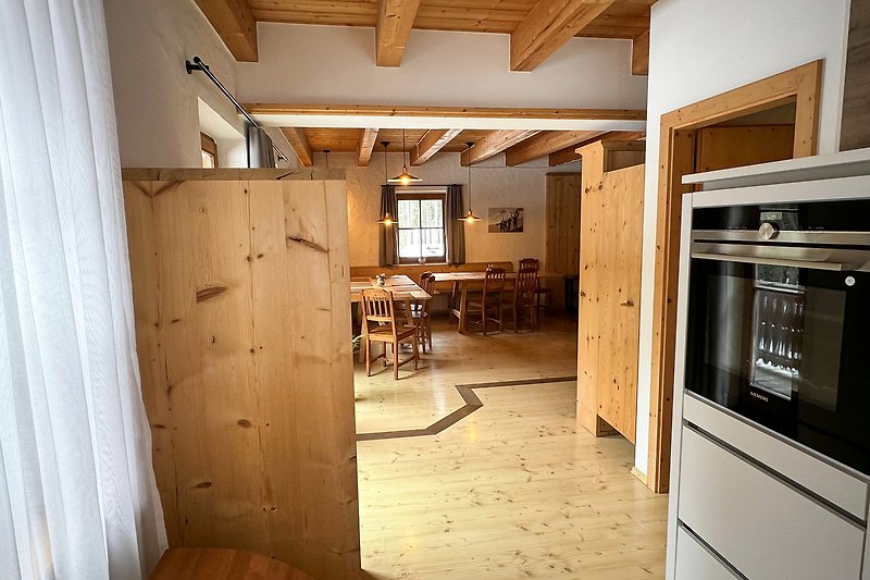 Moderne Küche mit Holzmöbeln, Gasherd und Kühlschrank.