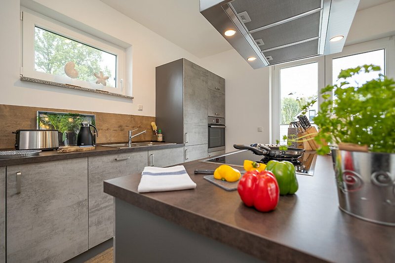 Moderne Küche mit Holzmöbeln, Pflanzen und Fensterblick.