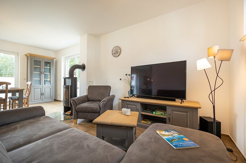 Stilvolles Wohnzimmer mit Fernseher, Couch, Lampe und Bilderrahmen.