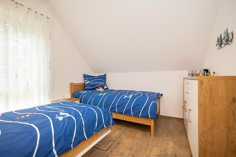 Modernes Schlafzimmer mit bequemem Bett, Holzmöbeln und gemütlichen Textilien.