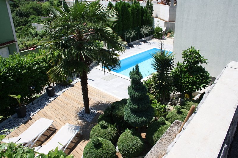 Luxuriöser Pool mit tropischer Landschaft und Stadtblick.