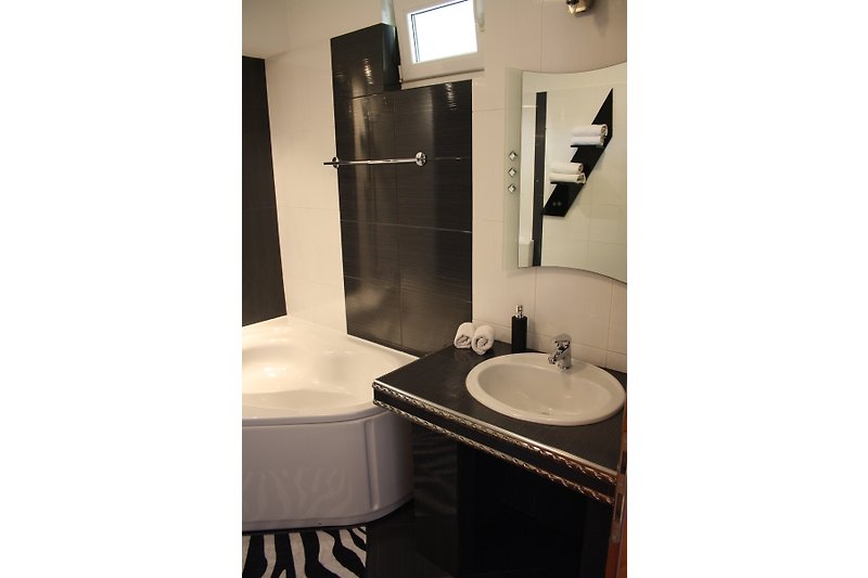 Modernes Badezimmer mit elegantem Spiegel und Armaturen.