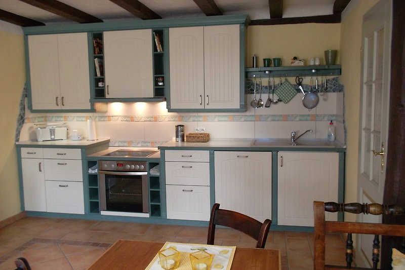 Moderne Küche mit Holzmöbeln und Küchengeräten.