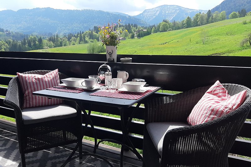 freier unverbauter Blick auf Berglandschaft mit Tisch und Stühlen, im Freien.