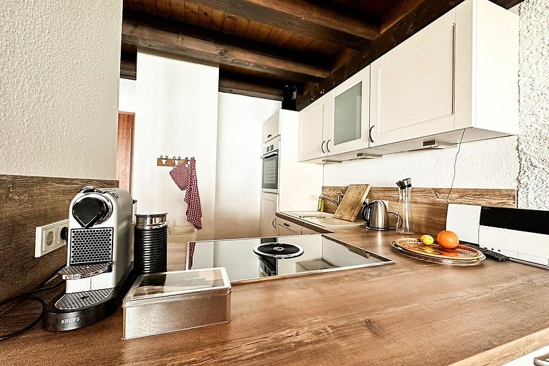 Moderne Küche mit Holzakzenten und Küchengeräten.