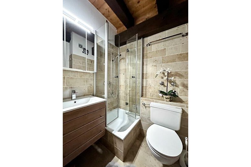 Modernes Bad mit Spiegel, Waschbecken und Toilette.