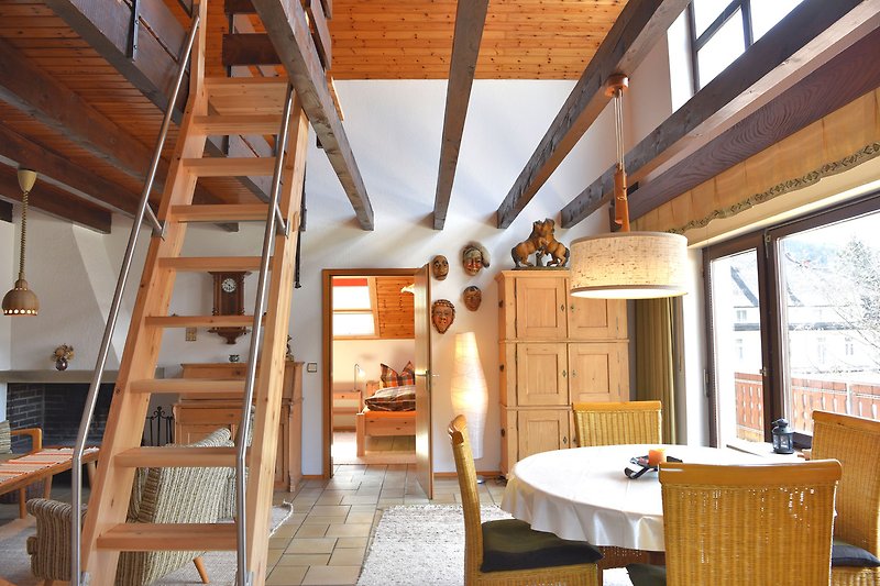 Wohnzimmer mit Holzmöbeln, Fenster und Tisch. Gemütliche Atmosphäre.