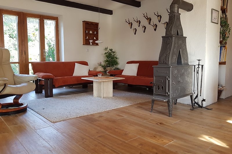 Wohnzimmer mit bequemer Couch und Holzofen