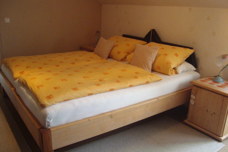 Doppelbett Schlafzimmer mit bequemem Bett, Holzmöbeln und Nachttischlampe