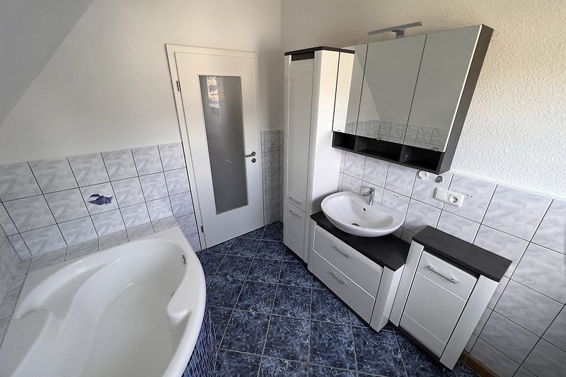 Badezimmer im 1. OG  mit großer Badewanne und Spiegelschrank