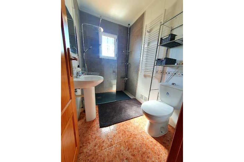 Obergeschoss Badezimmer mit Fenster, Toilette, Waschbecken und bodentiefer  Dusche.