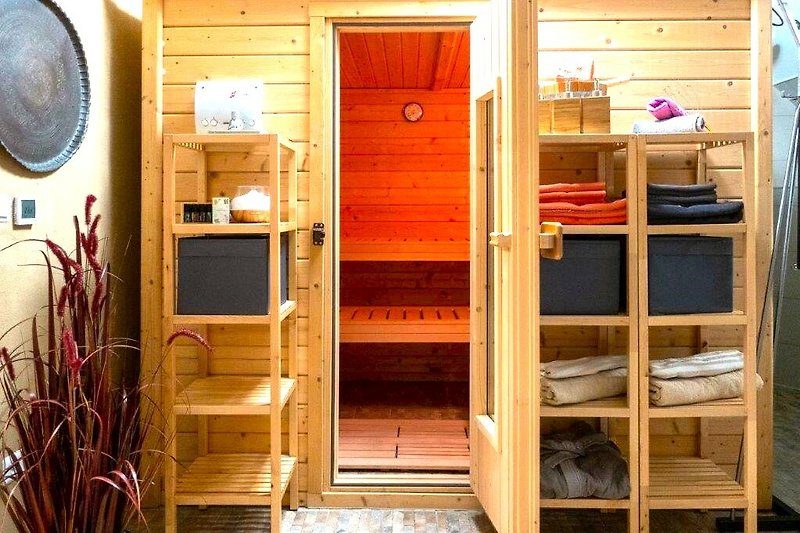 Massivholz-Sauna im Wellness-Badezimmer.