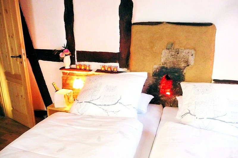 Stilvolles Schlafzimmer mit orangefarbener Bettwäsche und Holzbett. Gemütliche Beleuchtung!