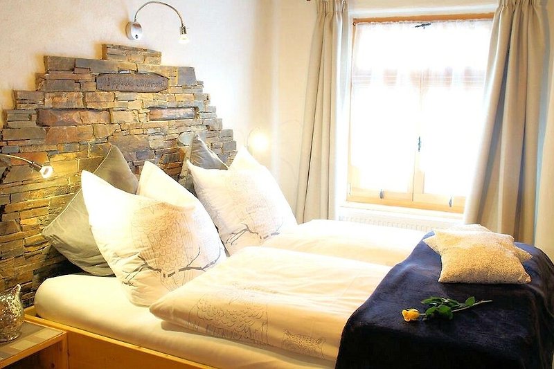 Stilvolles Schlafzimmer mit Holzbett, Kissen und Lampe. Gemütliche Atmosphäre.