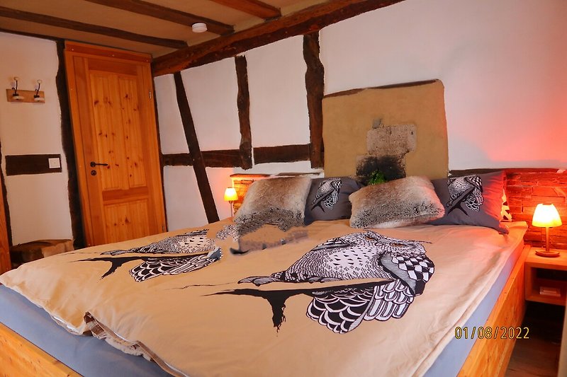 Stilvolles Schlafzimmer mit orange Bettwäsche, Holzbett und gemütlicher Beleuchtung. Gemütliche Atmosphäre!