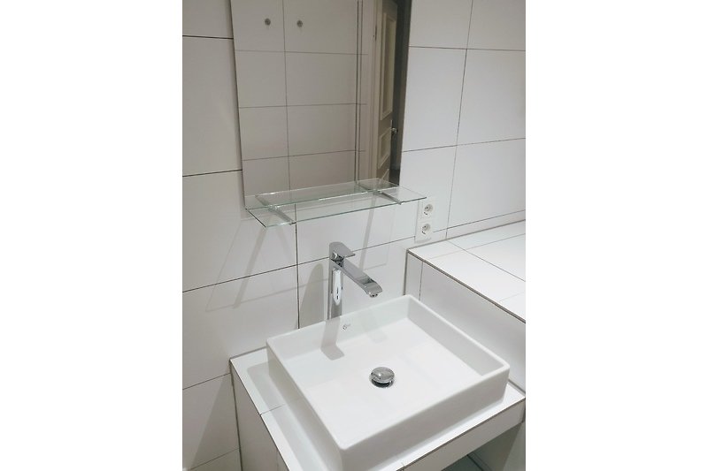 Spiegel und Waschbecken im Bad.