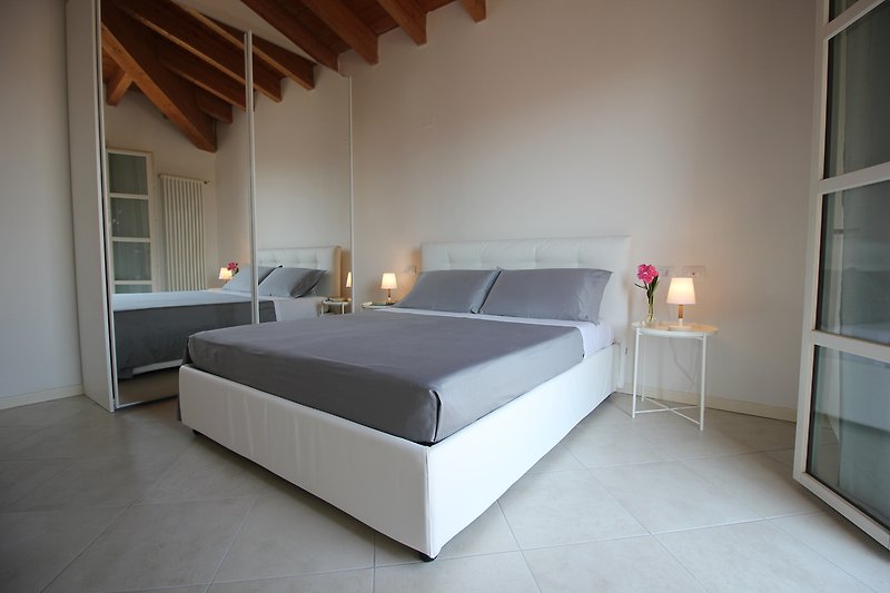 Stilvolles Schlafzimmer mit elegantem Bett und Lampenschirm.