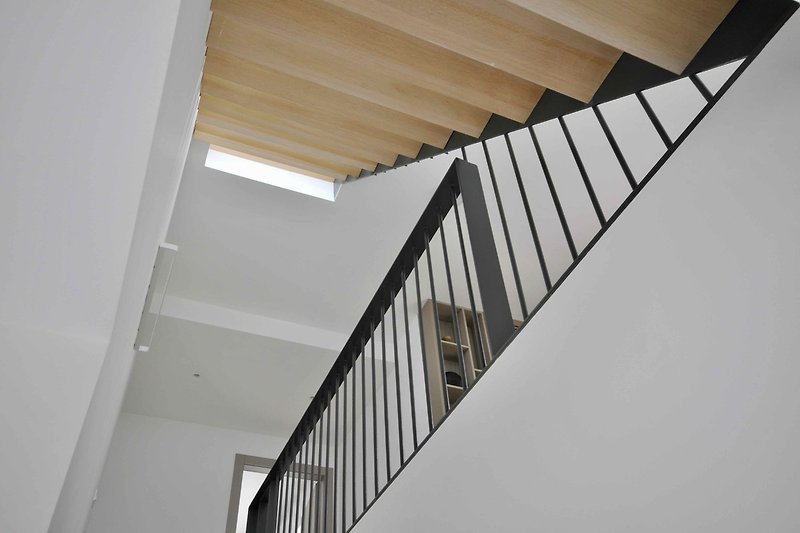 Moderne Treppe mit Glasgeländer und Metallbaluster.